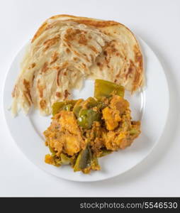 Aloo capsicum, potato and bell pepper vegetarian curry, served with paratha fried flatbread in the traditional way, viewed from above