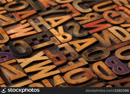 alphabet abstract - vintage wooden letterpress types, stained by color inks, selective focus