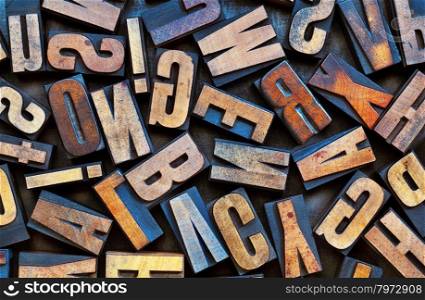 alphabet background - vintage letterpress wood printing blocks placed randomly on a grunge metal tray