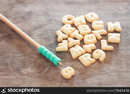 Alphabet biscuit on wooden table, stock photo