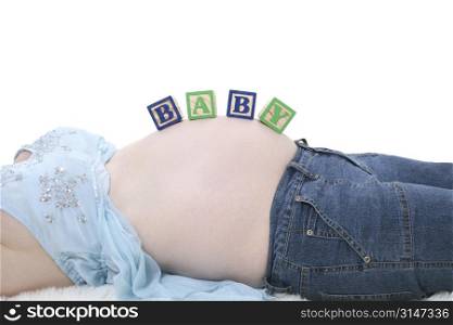 Alphabet Blocks Spell Baby Across Expecting Mom Belly.