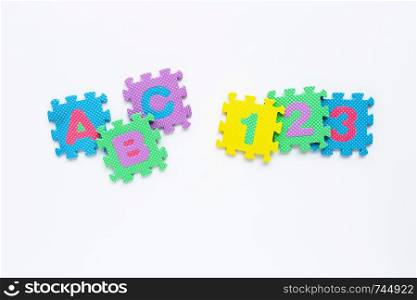 Alphabet puzzle with number puzzle on white background. Top view