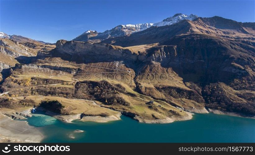 Alpine lake during Autumn with clear sky and mountains on the background