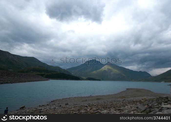 Alpine lake in mountains under clouds and sky in frence vacation