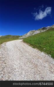 Alpine landscape with beautyful pathway under a bright blue sky