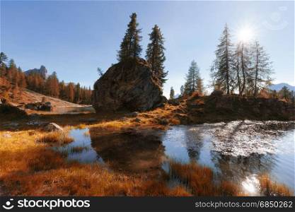 Alpine mountain autumn color lake at sunny day. Dolomites Alps, Italy