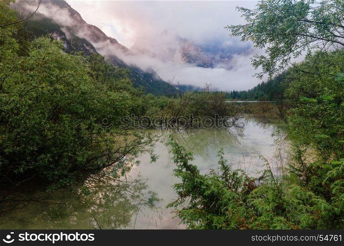 Alpine mountain lake at misty morning. Lago di Landro, Dolomites Alps, Italy