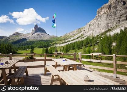 Alpine mountain rifugio wooden table. Outdoor restaurant