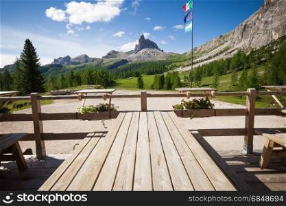 Alpine mountain rifugio wooden table. Outdoor restaurant