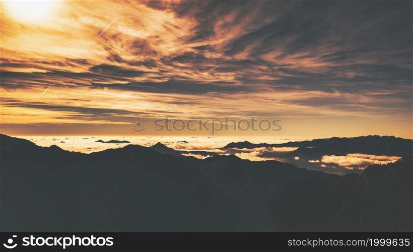 Alpine panorama with low clouds in the mountains. Idyllic landscape