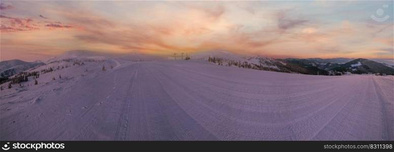 Alpine resort prepared ski slopes and lifts. Pre sunrise morning mountain ridge view. Dragobrat, Ukraine Carpathians.