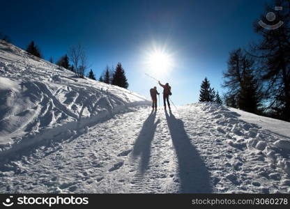 Alpine skiers uphill indicate mountain