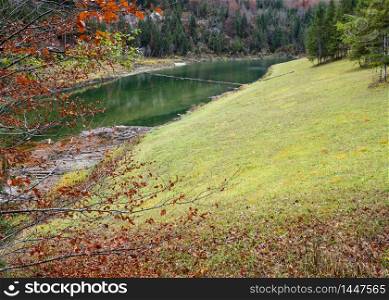 Alpine Sylvenstein Stausee lake on Isar river, Bavaria, Germany. Autumn overcast, foggy and drizzle day. Picturesque traveling, seasonal, weather, and nature beauty concept scene.