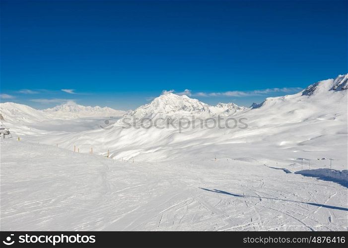 Alpine winter mountain landscape. French Alps covered with snow in sunny day. Val-d'Isere, France