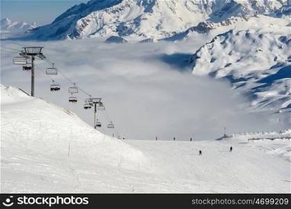 Alpine winter mountain landscape with ski lift and slopes. French Alps covered with snow in sunny day. Val-d'Isere, Alps, France