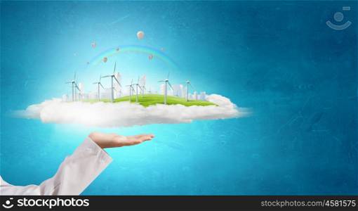 Alternative energy concept. Hands holding eco concept with windmill generators