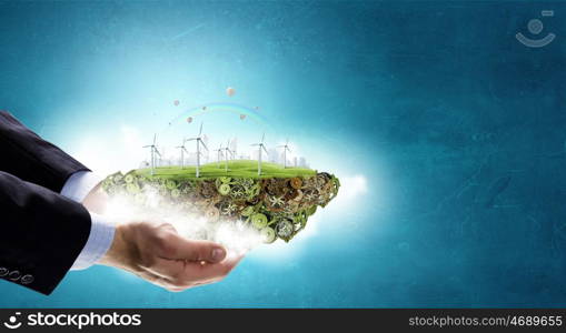 Alternative energy concept. Hands holding eco concept with windmill generators