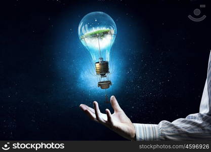 Alternative energy use. Male hand and light bulb as energy concept