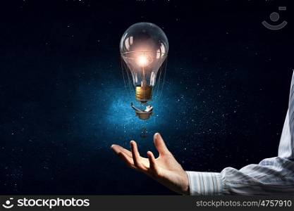 Alternative energy use. Male hand and light bulb as energy concept