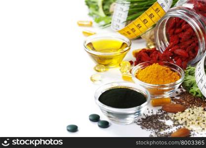 Alternative natural medicine. Dietary supplements. Spirulina, turmeric and organic oil on white background. Superfood, detox or diet concept. Background layout with free text space.