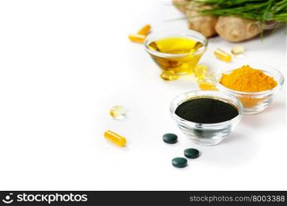 Alternative natural medicine. Dietary supplements. Spirulina, turmeric and organic oil on white background. Superfood, detox or diet concept. Background layout with free text space.