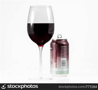 Aluminum can of California Pinot Noir behind a full glass of red wine showing move to single serving cans. Pinot Noir red wine in wine glass with a single serve aluminum can in background