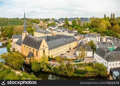 Alzette river bend with Saint Jean Du Grund cathedral and row of the houses behind, Luxembourg city, Luxembourg