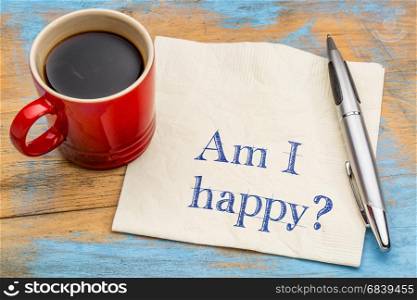 Am I happy question - handwriting on a napkin with a cup of coffee
