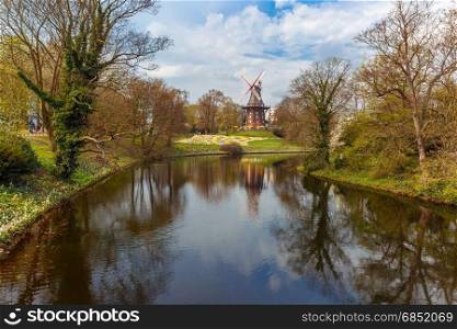 Am Wall Windmill in Bremen, Germany. Popular city park Wallanlagen with Am Wall Windmill and river in Bremen, Germany