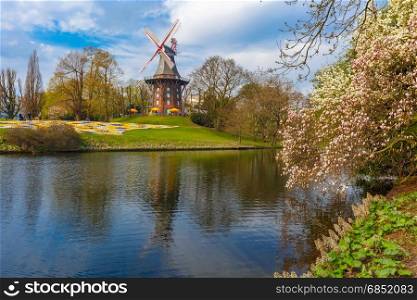 Am Wall Windmill in Bremen, Germany. Popular city park Wallanlagen with Am Wall Windmill and river in Bremen, Germany