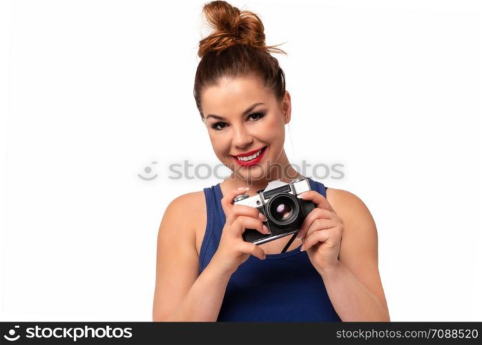 Amateur photographer concept - beautiful and attractive woman holding a retro SLR camera and smiling isolated on a white background.