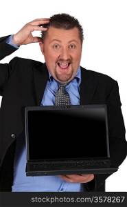 Amazed businessman holding a laptop computer with a screen left blank for your image