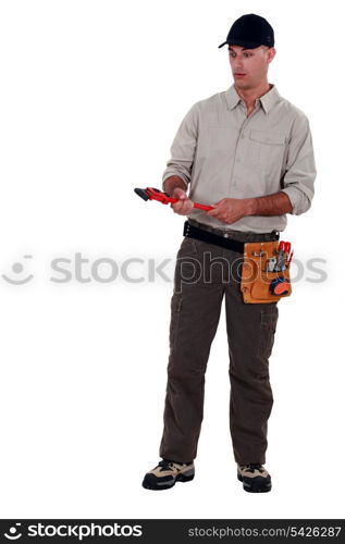 Amazed man holding a pipe wrench