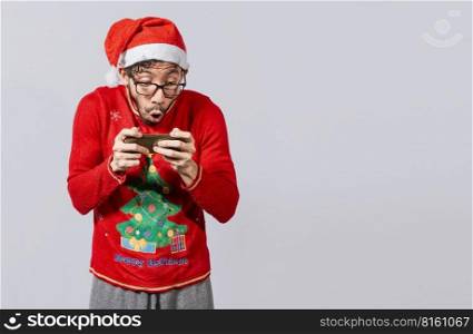 Amazed man looking at a christmas offer online, Guy looking at a christmas promo on phone. Online christmas special offers concept, Surprised people watching a christmas promotion on the phone