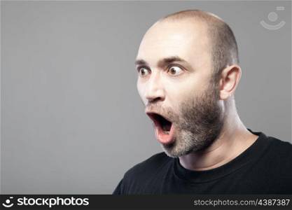 amazed man portrait isolated on gray background with copyspace
