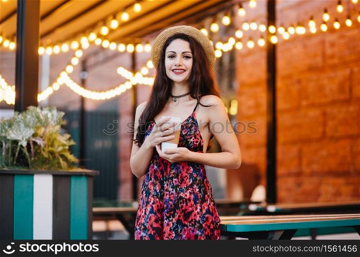 Amazed satisfied beautiful female model with dark straight hair, keeps mouth opened, hears unexpected news, poses against pink studio background. People, emotions, facial expressions, feelings concept