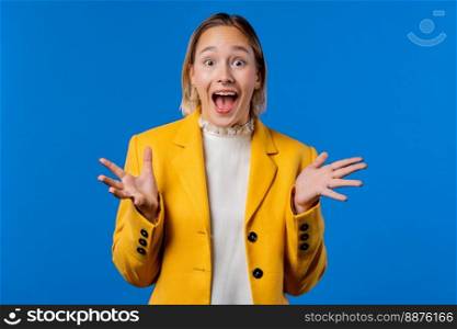 Amazed woman, she expresses WOW. Impressed businesswoman trying to get attention. Concept of sales, profitable offer. Excited hipster girl on blue background. High quality photo. Amazed woman, she expresses WOW. Impressed lady trying to get attention.