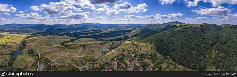 Amazing Aerial panorama from a drone of countryside fields, trees, a mountain peaks at cloudy day. Countryside. Stunning detailAmazing Aerial panorama from a drone of countryside fields, trees, a mountain peaks at cloudy day. Countryside. Stunning detail