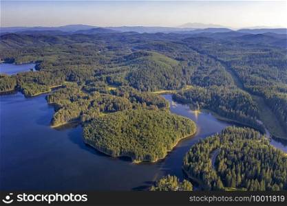 Amazing aerial view from drone of a beautiful panorama of blue water and green forest.