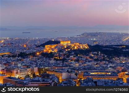 Amazing aerial view of Athens, Greece. Night over ancient Acropolis, ruins. Parthenon, the Icon of the hellenic civilization, Aegean sea on background. Traditional mediterranean architecture