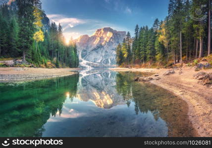 Amazing Braies lake at sunrise in autumn in Dolomites, Italy. Landscape with mountains, blue sky with clouds, water with reflection, trees with colorful leaves. Lake in fall. Italian alps. Panorama. Amazing Braies lake at sunrise in autumn in Dolomites, Italy