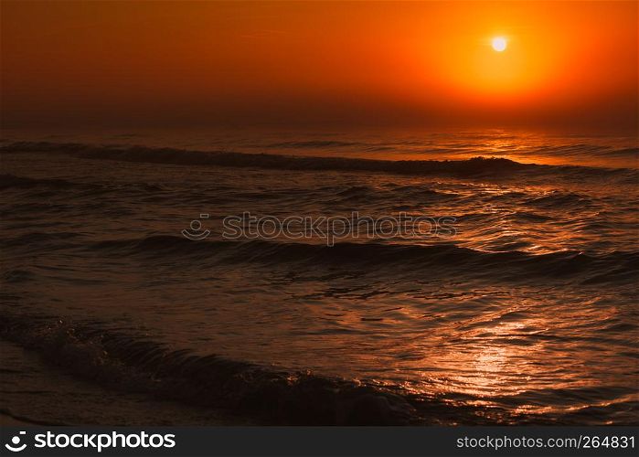 Amazing colorful red sunset over evening sea horizon. Tranquil scene. Natural background. Landscape.. Beatiful red sunset over sea surface