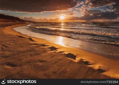 Amazing colorful sunset over evening sea horizon, clouds sky and sandy beach. Tranquil scene. Natural background. Landscape.. Beatiful sunset with clouds over sea and beach