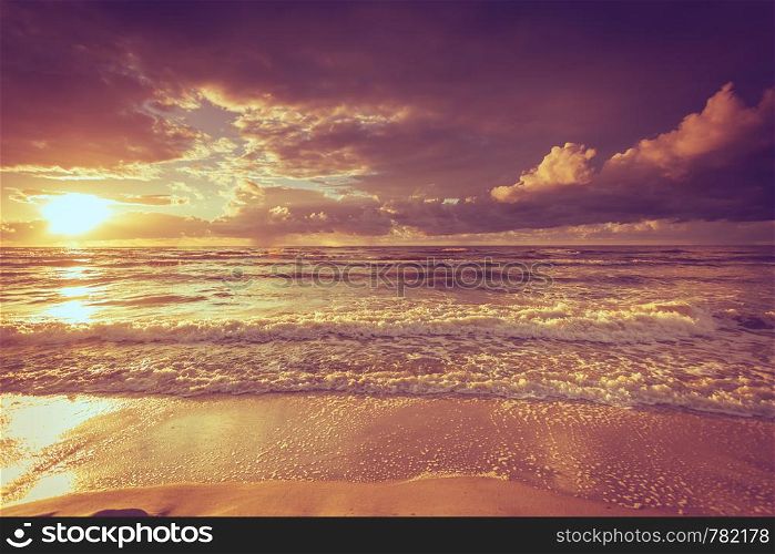 Amazing colorful sunset over evening sea horizon, clouds sky and sandy beach. Tranquil scene. Natural background. Landscape.. Beatiful sunset with clouds over sea and beach