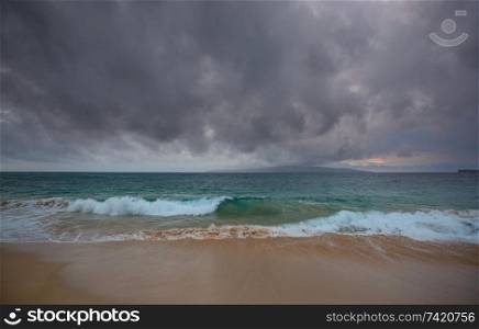 Amazing hawaiian beach. Wave in ocean at sunset or sunrise with surfer. Wave with warm sunset colors. Oahu beach, USA.