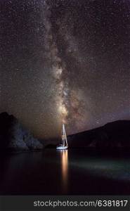 Amazing landscape of beautiful bright milky way on night starry sky, romantic traveling on sailboat at night, gorgeous nature view