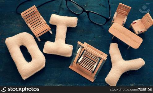 Amazing miniature handmade product for interior design, mini furniture make from wood stick on wooden background, small swing, chair so cute and diy knitted alphabet