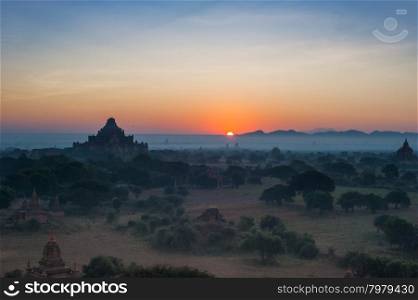 Amazing misty sunrise colors and silhouette of ancient Dhammayan Gyi Pagoda. Architecture of old Buddhist Temples at Bagan Kingdom, Myanmar (Burma). Travel landscapes and destinations