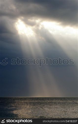 Amazing ray of light shines through storm clouds over ocean