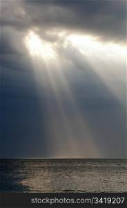 Amazing ray of light shines through storm clouds over ocean